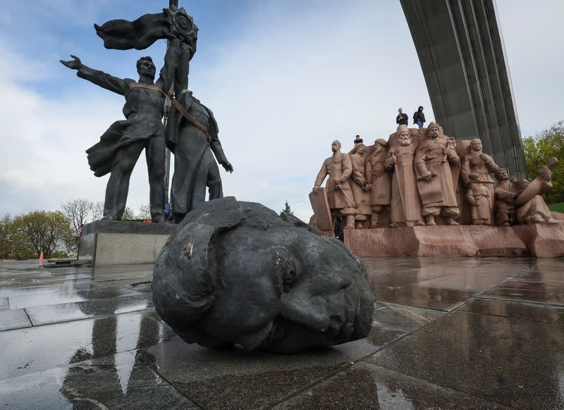 A Soviet monument to a friendship between Ukrainian and Russian nations is seen during its demolition in central Kyiv