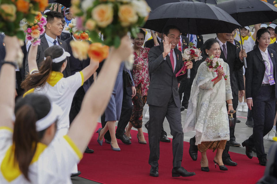 In this photo released by Xinhua News Agency, Indonesian President Joko Widodo, center, waves as he arrives in Chengdu in southwest China's Sichuan Province, Thursday, July 27, 2023. Widodo arrived in Chengdu on Thursday to attend the opening ceremony of the 31st summer edition of the FISU World University Games. (Jiang Hongjing/Xinhua via AP)