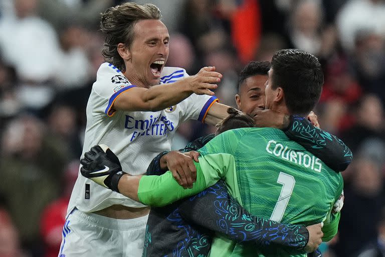 Real Madrid's goalkeeper Thibaut Courtois, right, celebrates with Real Madrid's Luka Modric after the Champions League final soccer match between Liverpool and Real Madrid at the Stade de France in Saint Denis near Paris, Saturday, May 28, 2022. Real won 1-0. (AP Photo/Petr David Josek)