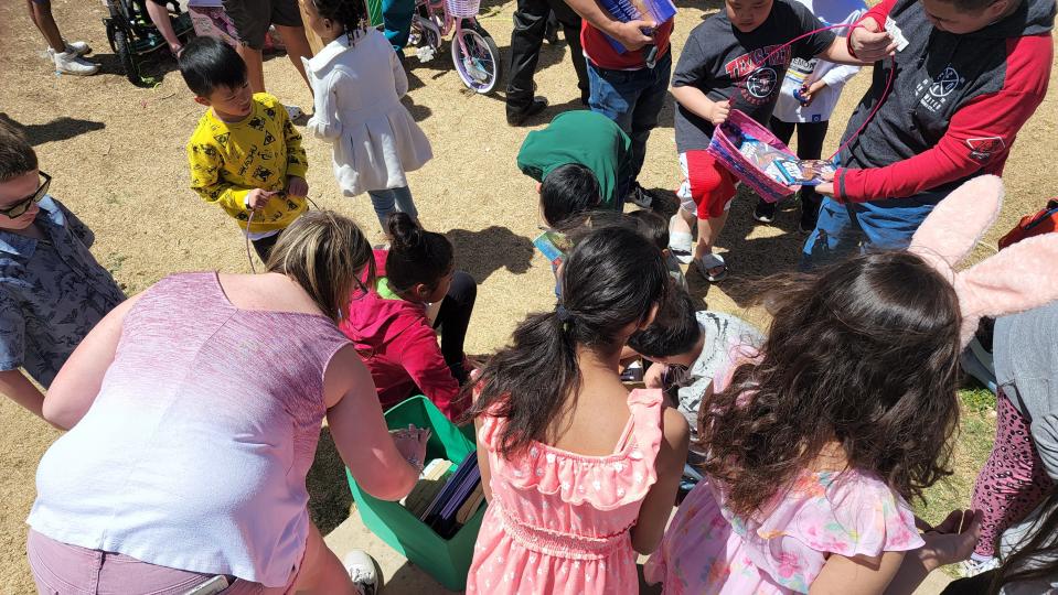 Children look over books at Bones Hooks Park during a previous Shi Lee's Easter Egg Hunt.