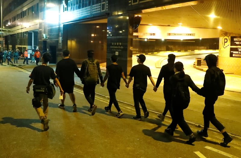 Anti-government protesters leave the campus of the Polytechnic University (PolyU) to give themselves up to the police in Hong Kong