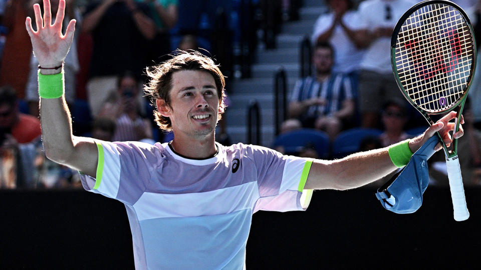 Alex de Minaur raises his arms to the crowd after defeating Benjamin Bonzi at the Australian Open.