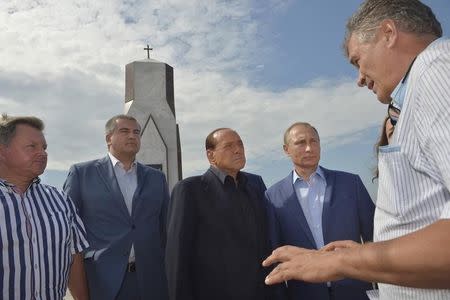 Russian President Vladimir Putin (R), former Italian Prime Minister Silvio Berlusconi (2nd R) and Crimean Prime Minister Sergei Aksyonov (2nd L) listen to explanations as they visit a monument to soldiers of the Kingdom of Sardinia, killed during the Crimean War, near Mount Gasfort in Crimea, September 11, 2015. REUTERS/Alexei Druzhinin/RIA Novosti/Kremlin