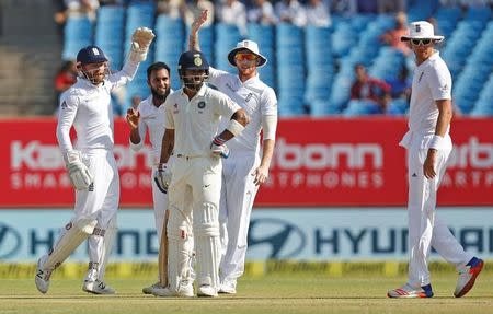 Cricket - India v England - First Test cricket match - Saurashtra Cricket Association Stadium, Rajkot, India - 12/11/16. England's Adil Rashid (2nd L) celebrates after dismissing India's Virat Kohli (C). REUTERS/Amit Dave