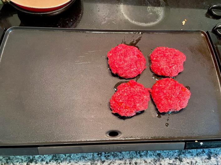 Patties on griddle for Gordon Ramsay's Burger