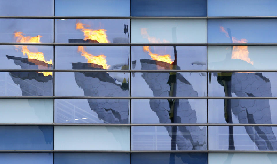 The Olympic cauldron is reflected in windows on the Iceberg Skating Palace ice skating venue at the 2014 Winter Olympics, Tuesday, Feb. 11, 2014, in Sochi, Russia. 