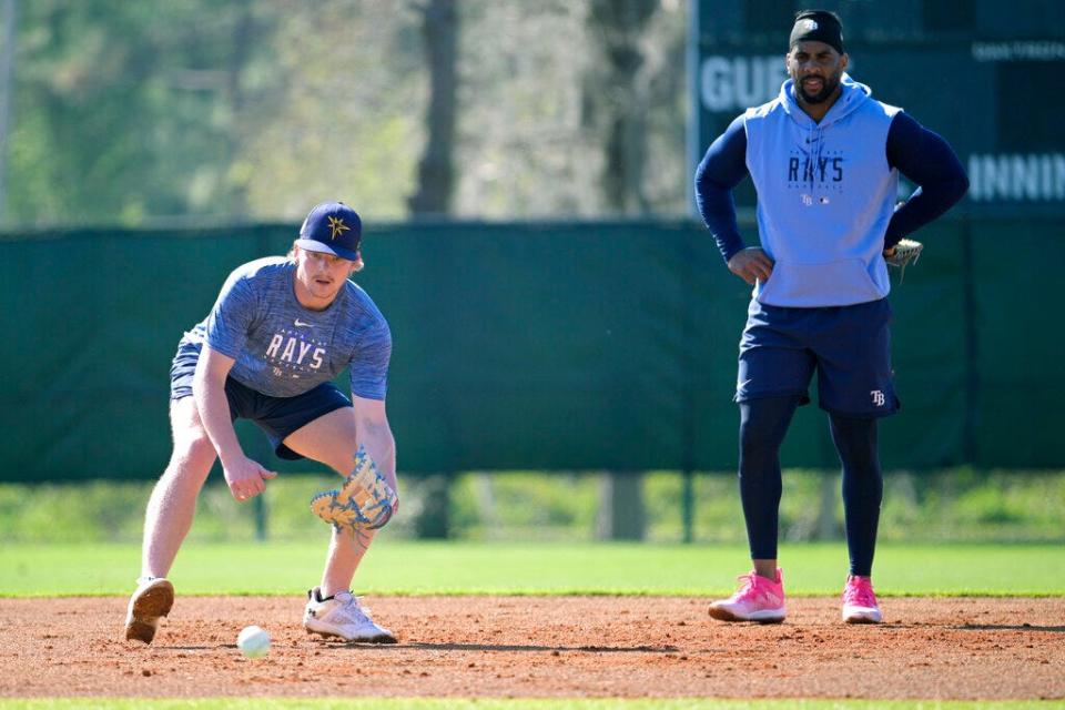 Tampa Bay Rays first basemen Kyle Manzardo, left, and Yandy Diaz field ground balls during practice at spring training baseball camp, Wednesday, Feb. 22, 2023, in Kissimmee, Fla. (AP Photo/Phelan M. Ebenhack)