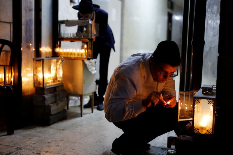 Jewish seminary students light hanukkiyot, candlesticks with nine branches as they mark Hanukkah, the 8-day Jewish Festival of Lights, at the entrance to their dormitories in Bnei Brak, Israel