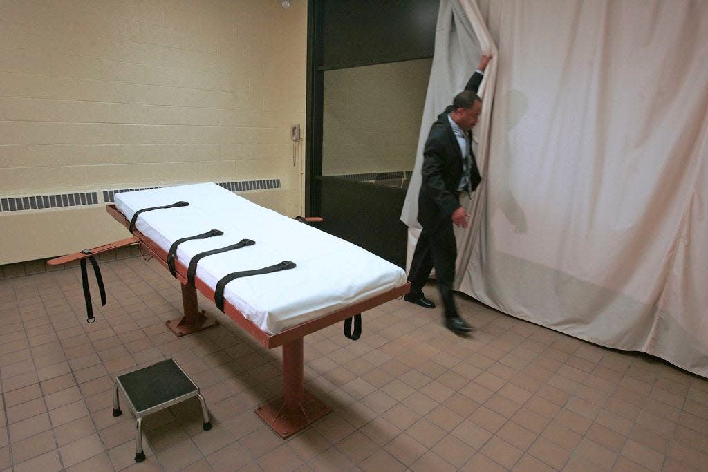 In this November 2005 file photo, Larry Greene, public information director of the Southern Ohio Correctional Facility, demonstrates how a curtain is pulled between the death chamber and witness room at the prison in Lucasville, Ohio