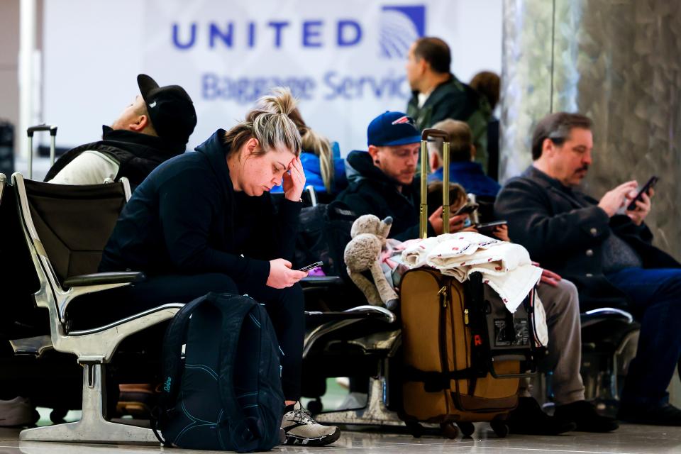 Mairi Risner sits at Denver International Airport after her flight was canceled due to a winter storm on February 22, 2023.