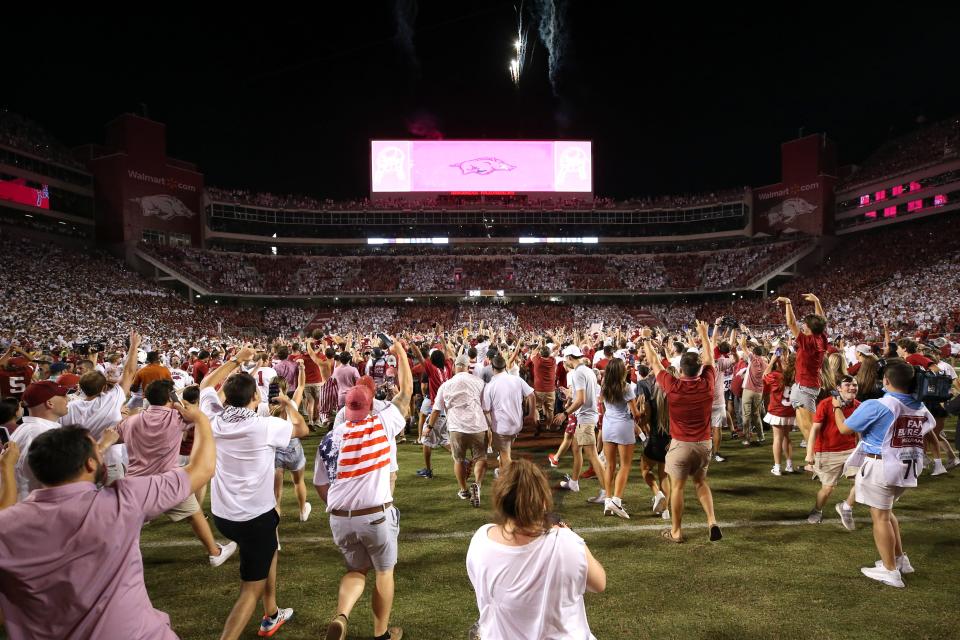 Arkansas fans rush the field after the Razorbacks' 40-21 win in 2021 at Fayetteville, Ark. The two former Southwest Conference rivals will be foes again when the Longhorns join the SEC in 2024.