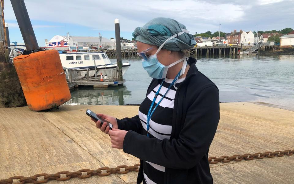 UK National Health Service employee Anni Adams looks at new NHS app to trace contacts with people potentially infected with the coronavirus disease (COVID-19) being trialled on Isle of Wight, Britain, May 5, 2020 - Reuters