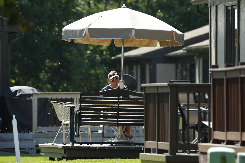 Father Eduard Perrone reads under an umbrella in Warren, Mich., Friday, June 7, 2019. On Sunday, July 7, the Roman Catholic Archdiocese of Detroit said it had removed Perrone, one of Opus Bono Sacerdotii's co-founders, from public ministry after a church review board decided there was a “semblance of truth” to allegations that he abused a child decades ago. Perrone told the AP that he “never would have done such a thing.” (AP Photo/Paul Sancya)