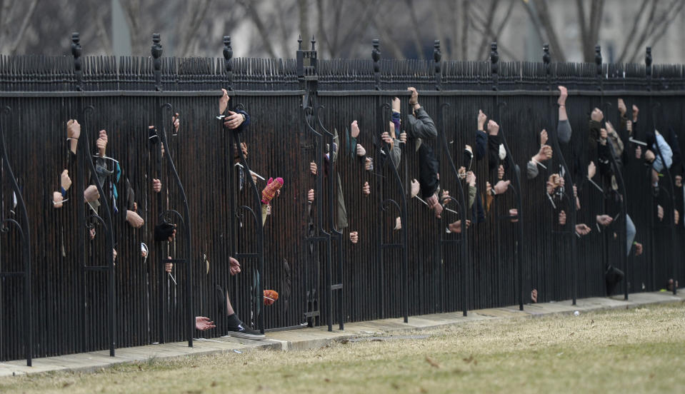 Several hundred students and youth who marched from Georgetown University to the White House to protest the Keystone XL Pipeline tied themselves to the fence outside the White House in Washington, Sunday, March 2, 2014. Many of those protesting were arrested. (AP Photo/Susan Walsh)