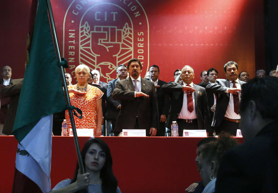 Miners' Union leader Napoleon Gomez Urrutia, center, who is also serves as a senator, salutes during the playing of the Mexican national anthem which opens the inauguration ceremony for his new, International Labor Confederation (CIT), in Mexico City, Wednesday, Feb. 13, 2019. Urrutia says 150 unions have joined the CIT and that other unions have expressed interest in joining, the latest sign that Mexico's long-dormant labor movement is awakening and one month after massive walkouts began at border assembly plants in Matamoros. (AP Photo/Marco Ugarte)