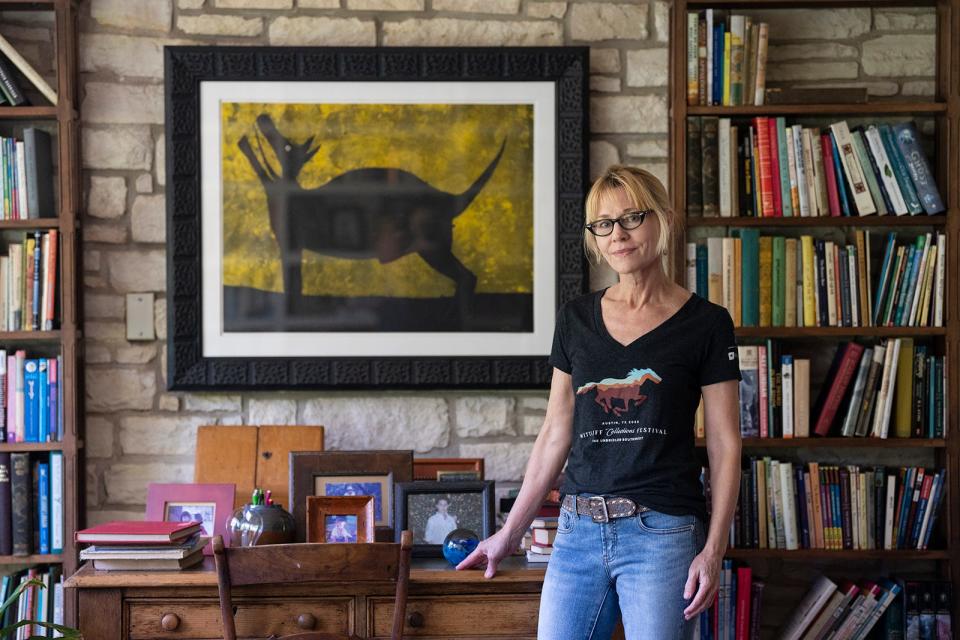 Elizabeth Crook with pictures of her ancestors in a parlor next to her office.