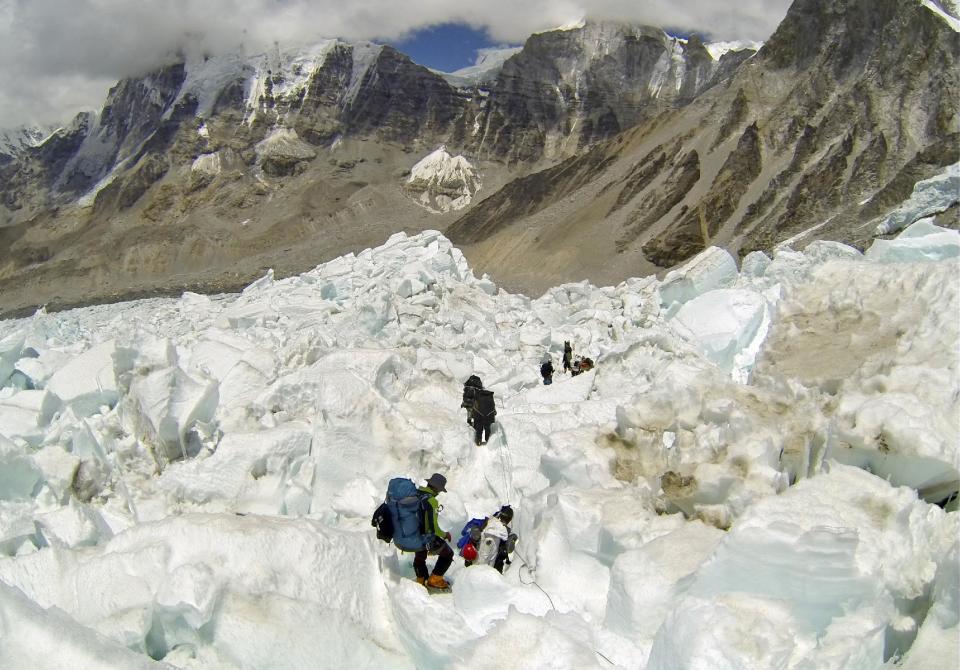 FILE - In this May 22 2013 file photo, climbers descend Khumbu Icefall on their way back to Base Camo after summitting the 8,850-meter (29,035-foot) Mount Everest. With its dreams of covering a daredevil's attempt to jump off Mount Everest over, the Discovery network is instead making a documentary on the avalanche, Friday, 18, 2014, that killed more than a dozen mountain guides. Discovery President Eileen O'Neill said Tuesday, April 22, the network hopes to air the film within the next few weeks. Discovery will encourage viewers to donate to a relief fund for families of the Sherpa guides killed in the disaster. Several of the Sherpas killed were helping prepare for American Joby Ogwyn's planned jump from the summit in a wingsuit. Discovery planned to show the stunt on live television May 11.(AP Photo/ Pasang Geljen Sherpa, FIle)