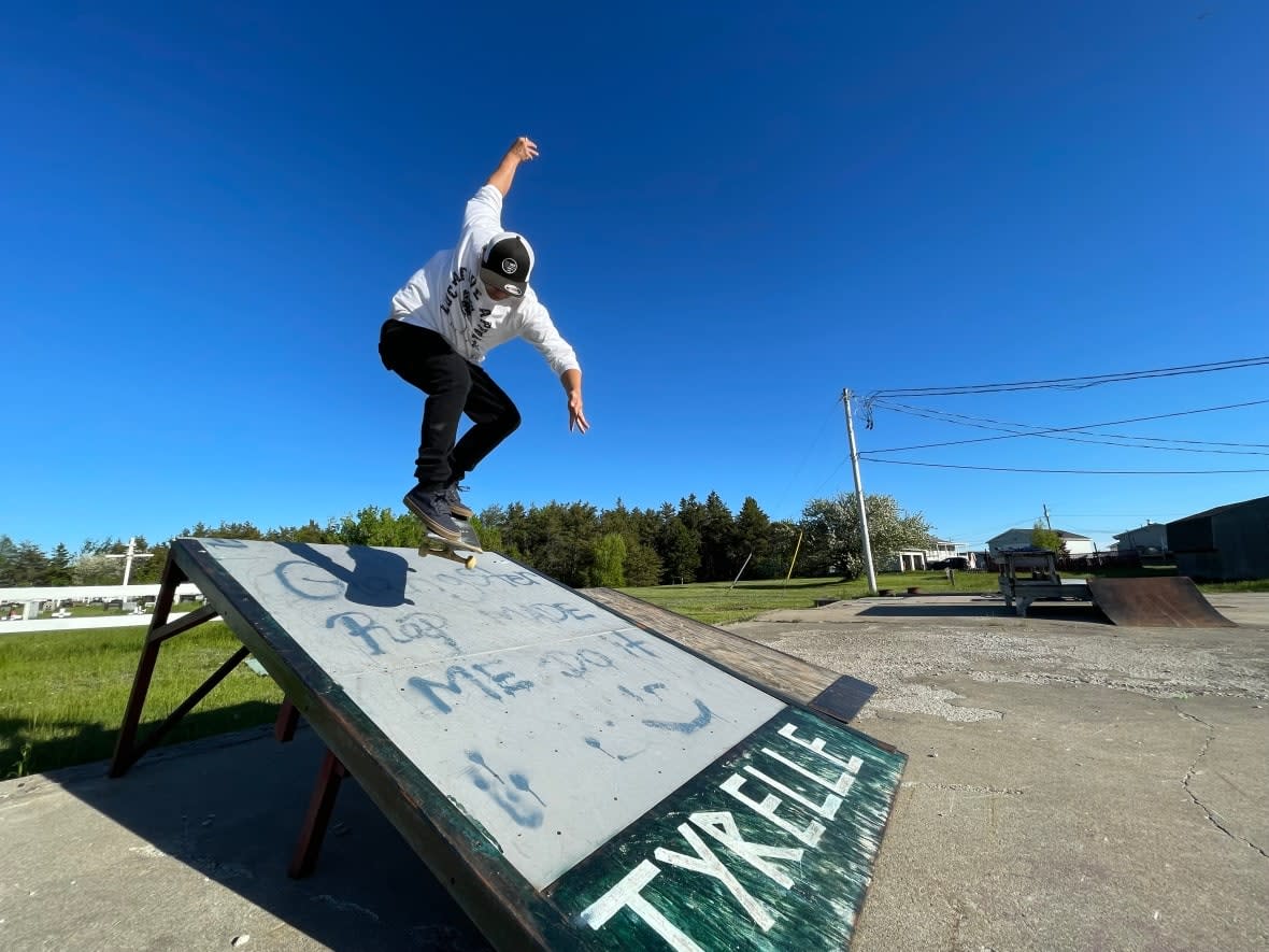 Frank Johnson skateboards on one of the homemade ramps at 'the slab,' an old foundation in Esgenoôpetitj First Nation currently used by skateboarders. (Alexandre Silberman/CBC - image credit)