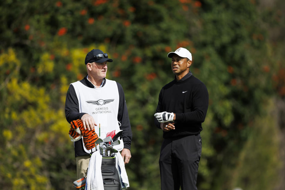 FILE - Tiger Woods talks with caddie Joe LaCava on the fourth tee during the second round of the Genesis Invitational golf tournament at Riviera Country Club, Friday, Feb. 17, 2023, in the Pacific Palisades area of Los Angeles. Woods won't be at the Wells Fargo Championship, but his caddie will be. Or rather, his former caddie. Joe LaCava, who was on the bag for Woods since 2011 and helped him win his fifth Masters in 2019, has moved on to caddie for Patrick Cantlay for the remainder of the season.(AP Photo/Ryan Kang, File)