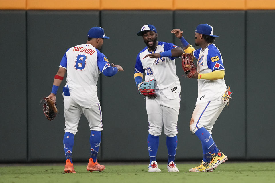 From left to right, Atlanta Braves outfielders Eddie Rosario (8), Michael Harris II and Ronald Acuna Jr. celebrate after defeating the Milwaukee Brewers in a baseball game Friday, July 28, 2023, in Atlanta. (AP Photo/John Bazemore)