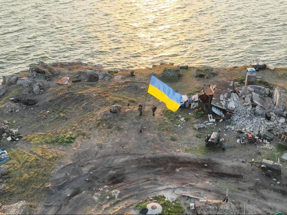 Ukrainian service members install a national flag on Snake Island (Press service of the Ukrainian Armed Forces/Handout via Reuters)