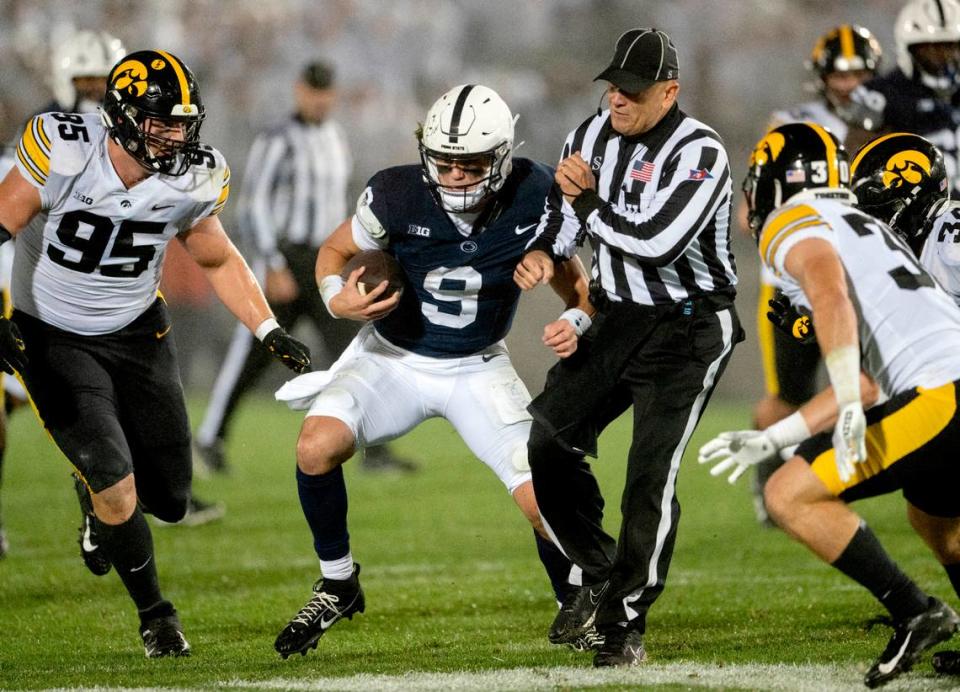 Penn State quarterback Beau Pribula cuts down the field around Iowa defenders and a referee during the game on Saturday, Sept. 23, 2023.