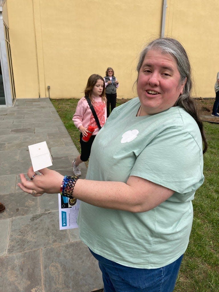 Mari Weiss of Newark shows off the camera obscura she made to look at the eclipse while attending the Delaware Museum of Nature and Science eclipse viewing party on April 8, 2024.