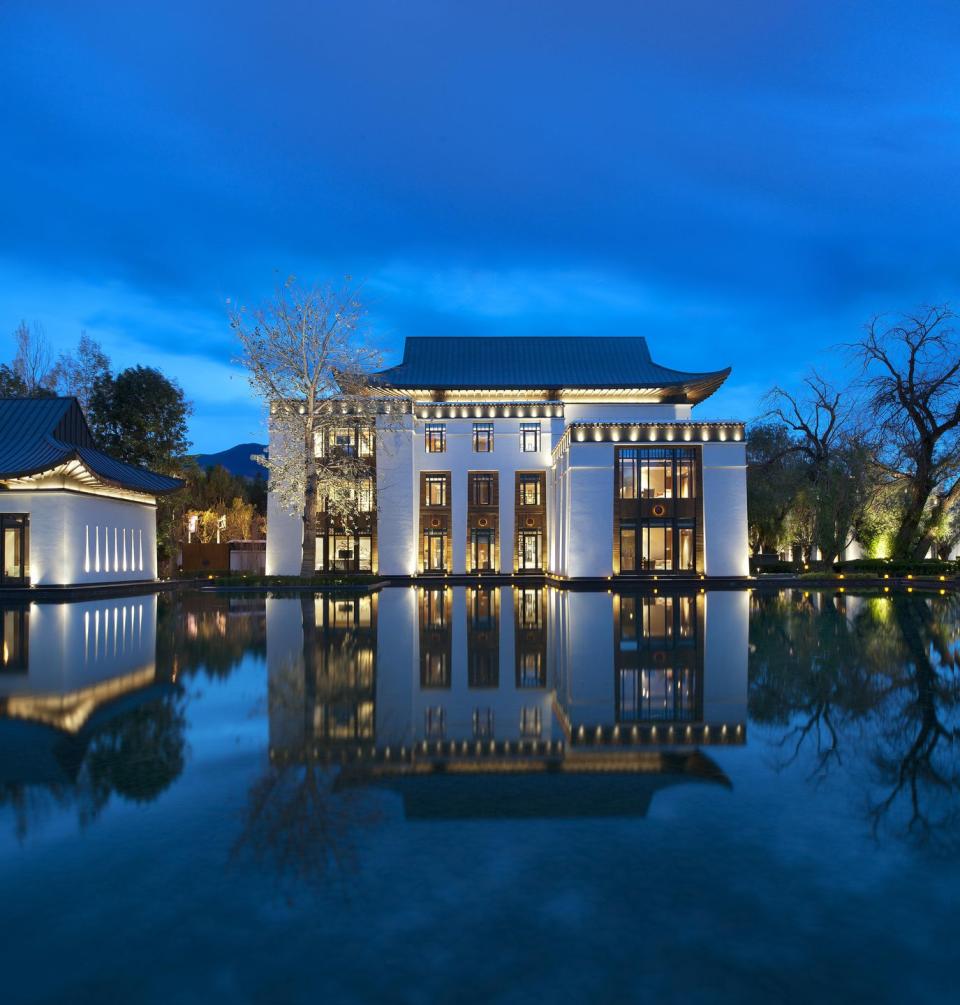 a house with a pool in front of it with hearst castle in the background