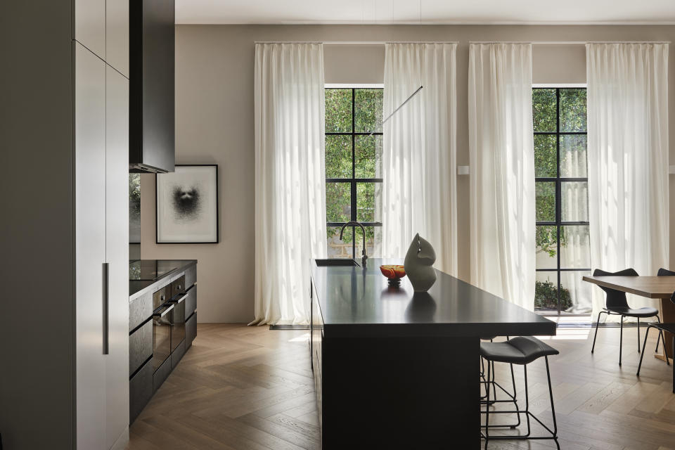 A kitchen with long, cotton curtains