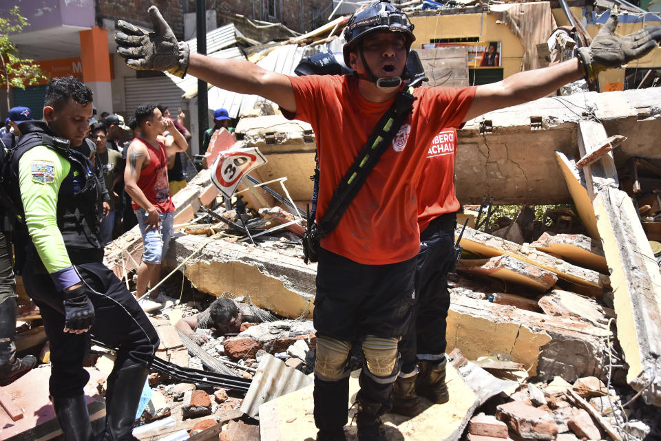 Varios socorristas buscan sobrevivientes entre los escombros tras la caída de un inmueble por un fuerte sismo en Machala, Ecuador, el sábado 18 de marzo de 2023. (AP Foto/Jorge Sanchez)