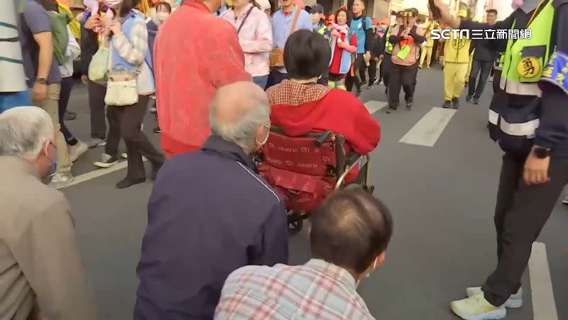 因車禍導致得坐輪椅的女信眾聽聞媽祖要經過，趕緊從家中坐輪椅出來祈求平安。