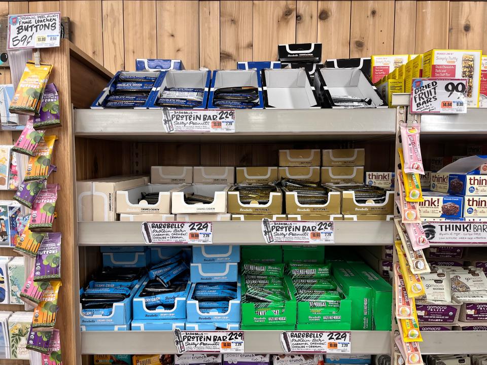 Display shelves at Trader Joe's with blue, green, brown, and black bars of Barebells protein bars