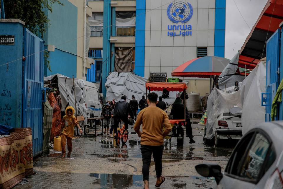 Palestinians walk at the entrance of a UNWRA school used as shelter in Gaza City. Key donors have paused funds to the U.N. agency after a claim staff participated in Hamas attacks on Israel.  / Credit: OMAR EL-QATTAA/AFP via Getty Images