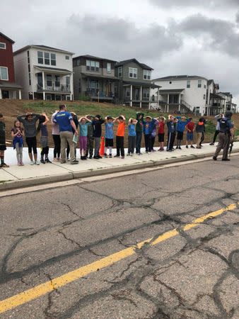 Schoolchildren stand in a line outside near the STEM School during a shooting incident in Highlands Ranch, Colorado, U.S. in this May 7, 2019 image obtained via social media. SHREYA NALLAPATI/VIA REUTERS