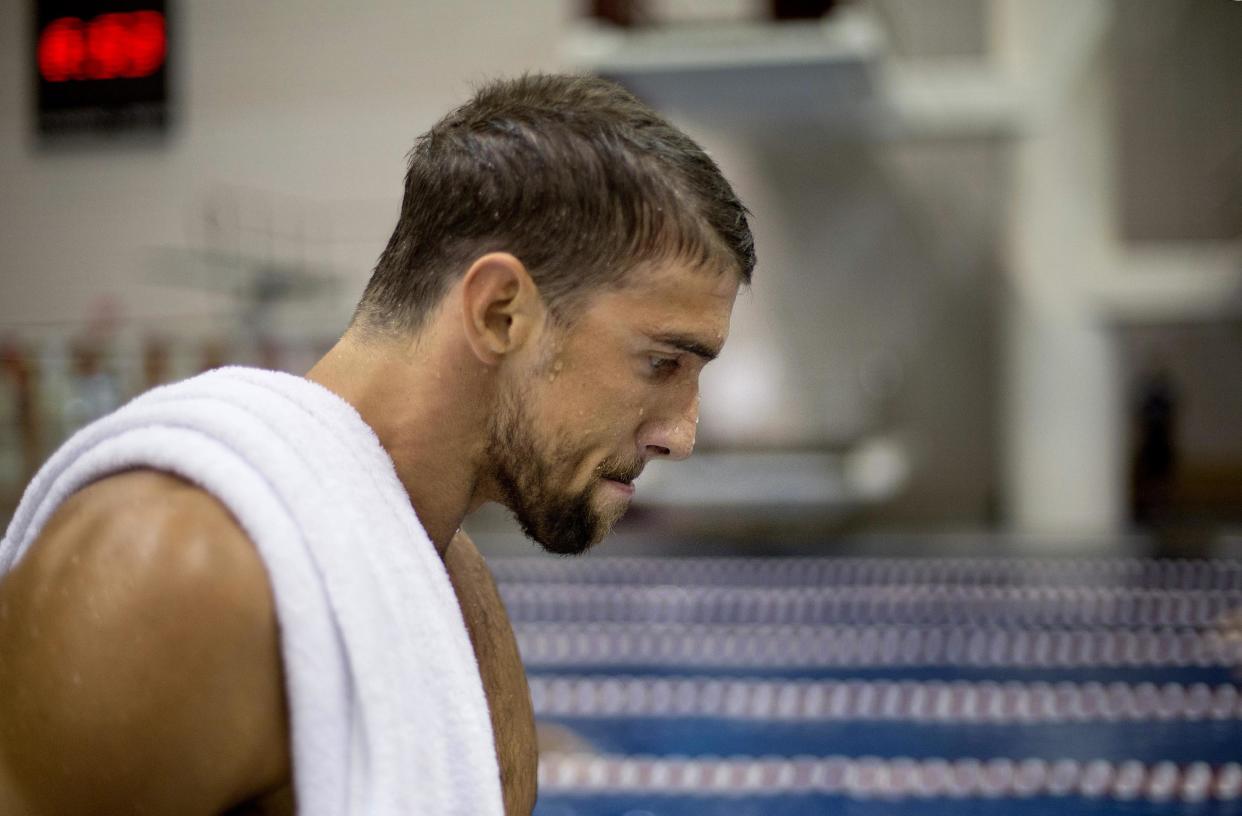 El nadador estadounidense Michael Phelps camina tras ganar una carrera de los 100 metros mariposa el 11 de julio de 2014 en Athens, Georgia. Phelps fue arrestado por conducir ebrio el 30 de septiembre de 2014 en Baltimore, Maryland. (AP Photo/David Goldman, File)