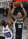 San Antonio Spurs' DeMar DeRozan (10) shoots against Sacramento Kings' Harrison Barnes during the first half of an NBA basketball game Wednesday, March 31, 2021, in San Antonio. (AP Photo/Darren Abate)