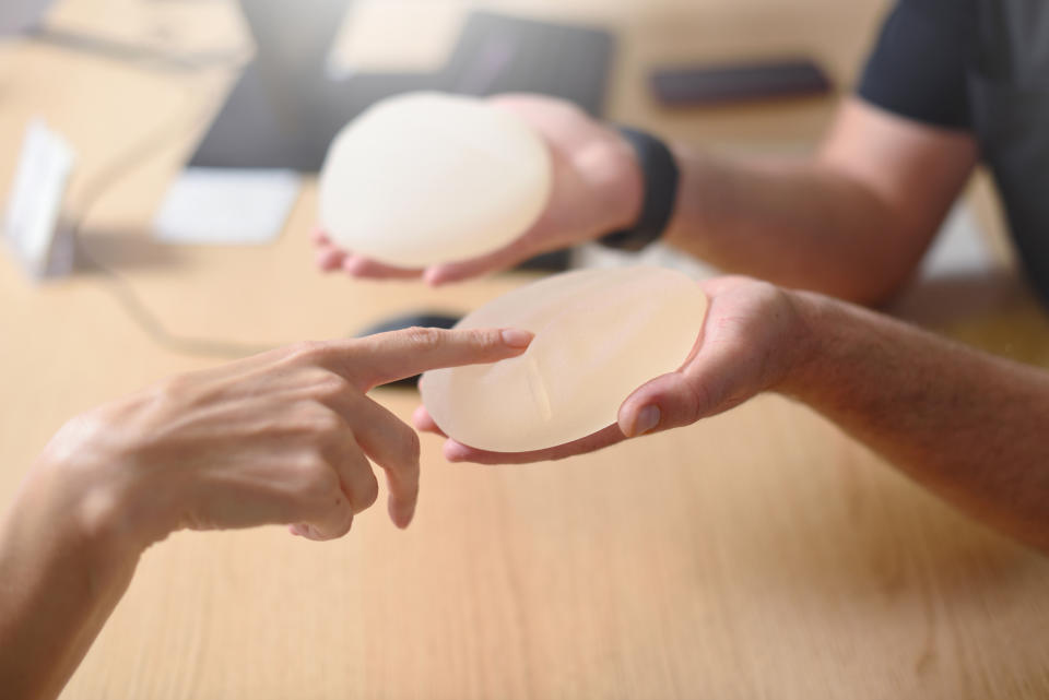 Two people examining a silicone breast implant