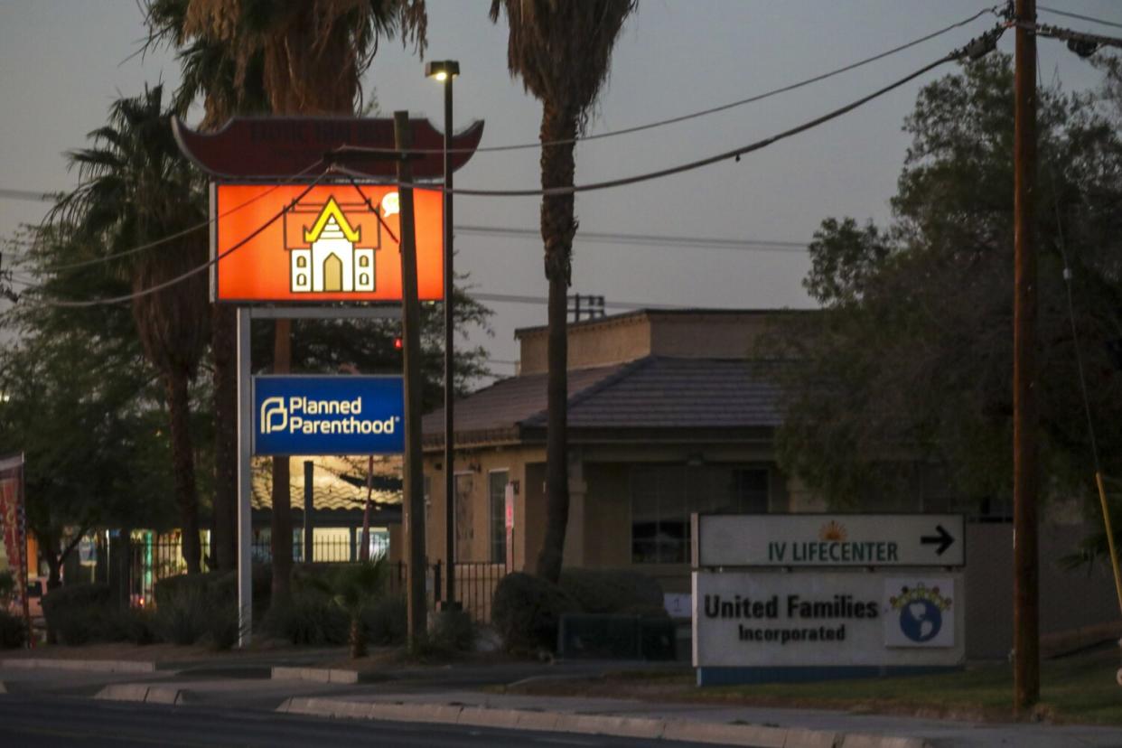 A "Planned Parenthood" sign outside a building on a street.