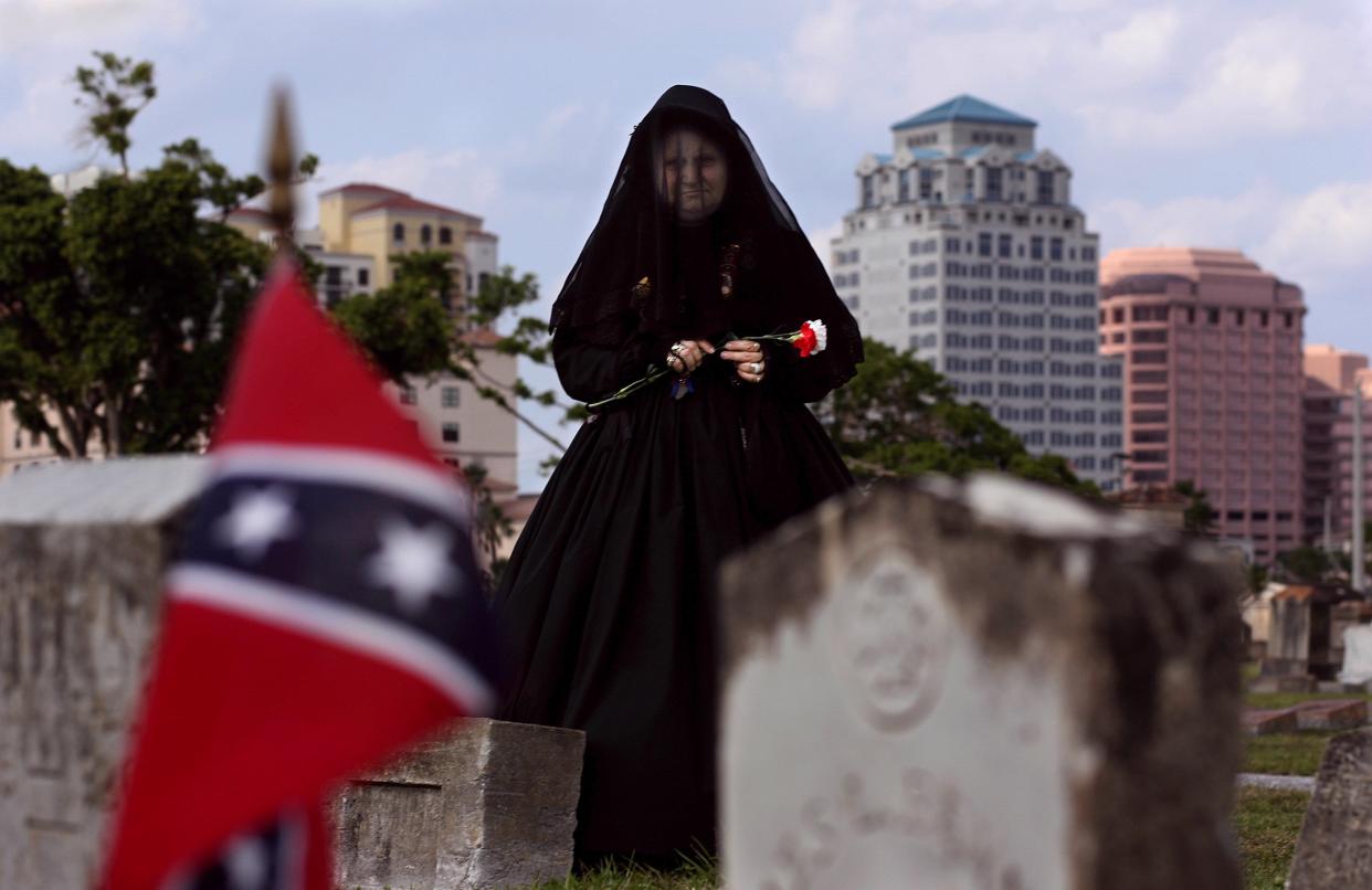 Kathy Clark, of Lantana, part of Daughters of the Confederacy the Margaret Mitchell Chapter, whose great-great-grandfather James Rowsey, of Virginia, was a Confederate soldier who died in the Civil War, places carnations on the graves of soldiers before the start of the 11th annual South Florida Confederate Memorial Day at Woodlawn Cemetery in West Palm Beach April 2006. The motorcade traveled through seven counties from Dade in the south and Indian River in the north placing carnations on 171 graves. There are 20 confederate soldiers buried at Woodlawn Cemetery.