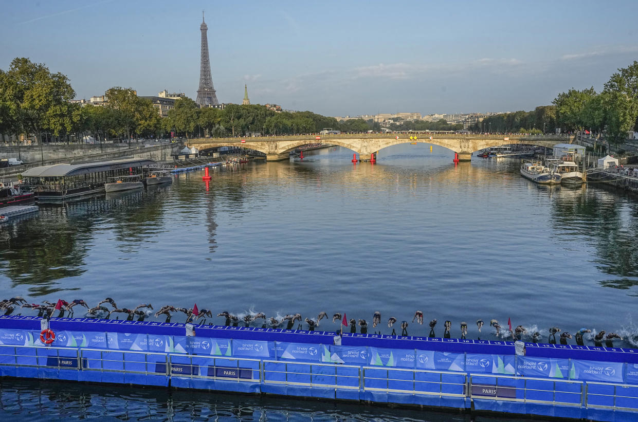 Athletes dive into the Seine river at the start of the women's triathlon test event for the 2024 Olympics Games on Aug. 17, 2023.  (Michel Euler / AP)