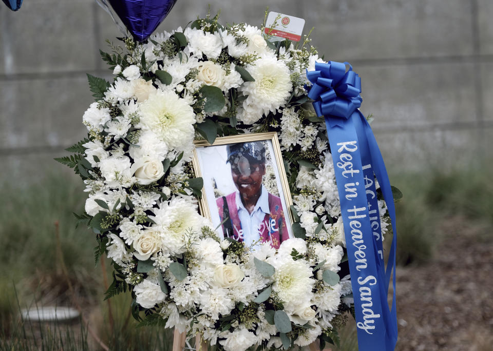 FILE - A photo of Sandra Shells is seen in a memorial wreath in downtown Los Angeles on Jan. 19, 2022, at the bus stop where she was attacked the week before. Three random killings: a woman pushed in front of a train, another punched at a bus stop and a third stabbed to death while working alone in a store, and three homeless men charged with the crimes have reignited anger and frustration with the intractable issue of homelessness in New York and Los Angeles. (AP Photo/Richard Vogel, File)