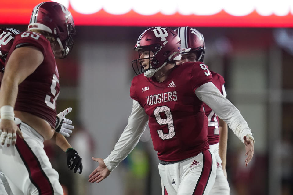 Indiana quarterback Connor Bazelak (9) celebrates with teammates after throwing a 52-yard touchdown pass to D.J. Matthews Jr. during the first half of an NCAA college football game against Illinois, Friday, Sept. 2, 2022, in Bloomington, Ind. (AP Photo/Darron Cummings)