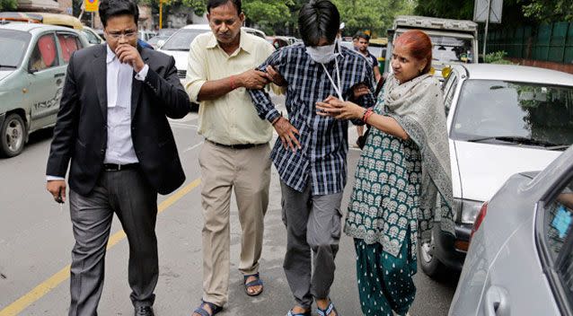 Puneet (second right) is helped by his parents outside a court in New Delhi in 2015. Source: AP Images