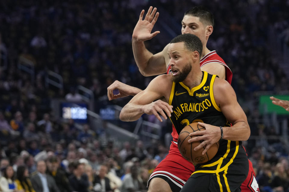 Golden State Warriors guard Stephen Curry drives against Chicago Bulls center Nikola Vucevic during the first half of an NBA basketball game Thursday, March 7, 2024, in San Francisco. (AP Photo/Godofredo A. Vásquez)