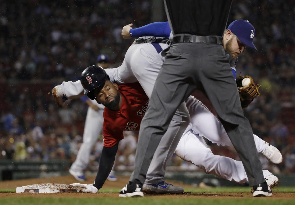 Boston Red Sox's Jackie Bradley Jr. , left, gets back safely to first base as Los Angeles Dodgers first baseman Max Muncy hangs on to the ball after a pickoff attempt during the seventh inning of a baseball game at Fenway Park, Friday, July 12, 2019, in Boston. (AP Photo/Elise Amendola)