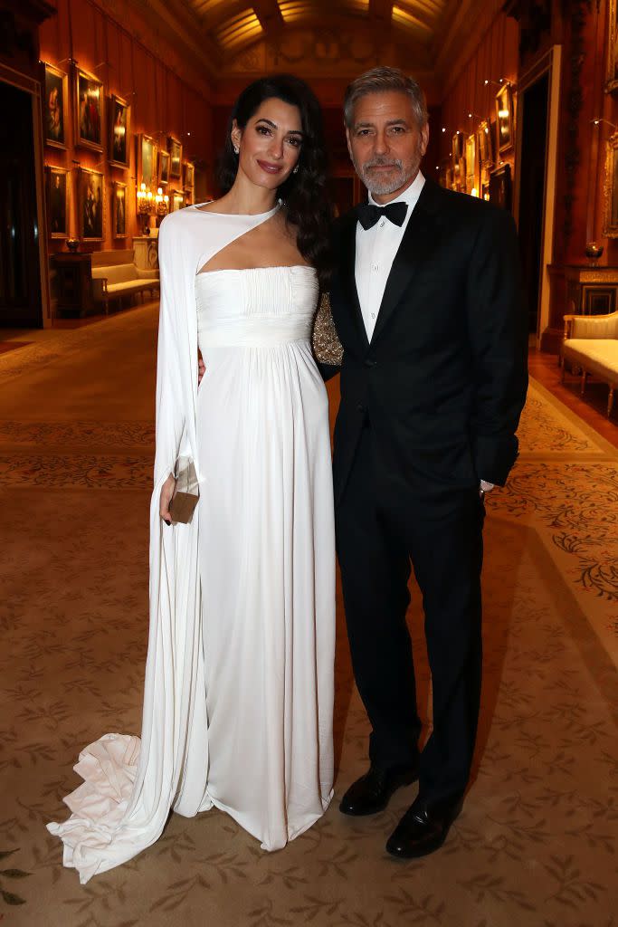 <p>Amal and George Clooney dressed up for a dinner celebrating the Prince's Trust at Buckingham Palace. Amal wore stunning white gown with an asymmetrical neckline to the event, which was hosted by Prince Charles.</p>