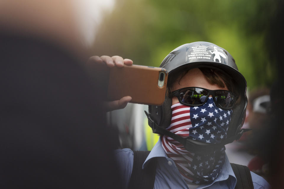 A white nationalist holds his phone while marching to Lafayette Square during the "Unite the Right 2" rally in Washington, Sunday, Aug. 12, 2018. (Craig Hudson/Charleston Gazette-Mail via AP)