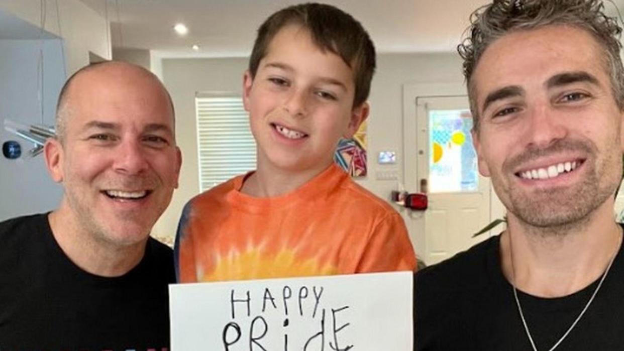 BJ Barone y Frankie Nelson con su hijo y un cartel de Happy Pride