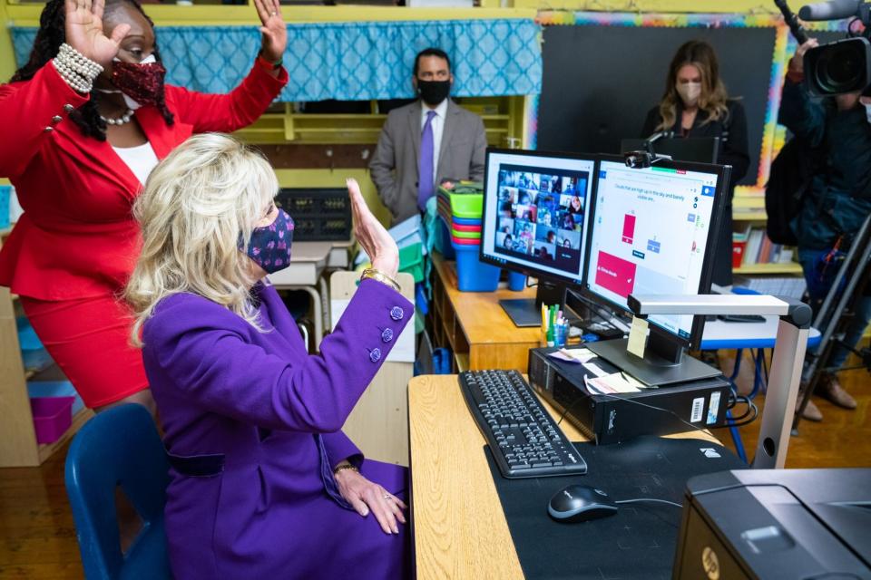First Lady Jill Biden waves at second grade students who are attending class virtually Monday, March 15, 2021, during her tour at the Samuel Smith Elementary School in Burlington, New Jersey.