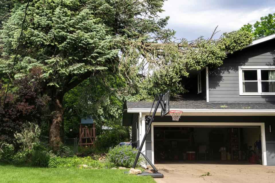 A tree limb sits against a house on Beverly Drive on Wednesday, May 22, 2024, in Urbandale.